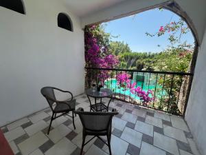 a patio with a table and chairs and a balcony with flowers at Hotel Posada La Catrina in Ciudad Fernández