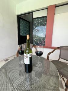 a bottle of wine sitting on a table with two glasses at Hotel Posada La Catrina in Ciudad Fernández