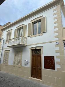 a white building with a wooden door and a balcony at Terracotta House in Porto Santo +19 photos