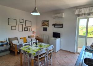 a kitchen and living room with a table and chairs at Le Palme Holidays in Palmadula