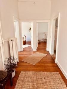 a living room with a wooden floor and white walls at Ambiente Deluxe Schloss Falkenhorst in Kleinblittersdorf