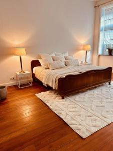 a bedroom with a bed with two lamps and a rug at Ambiente Deluxe Schloss Falkenhorst in Kleinblittersdorf