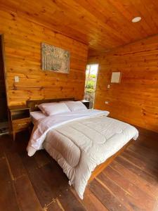 a bedroom with a bed in a wooden cabin at La Cima Bachué in Ubaque