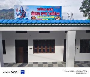 a sign on top of a white building at Shaaneshwar Mahadev Hotel & Restaurant in Phata