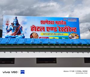 a billboard sign for a restaurant with a buddha on it at Shaaneshwar Mahadev Hotel & Restaurant in Phata