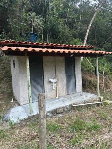 a small house with a porch with a roof at Camping Cachoeira Bem Vinda in Itabirito