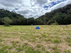 a blue object in a field with trees in the background at Camping Cachoeira Bem Vinda in Itabirito