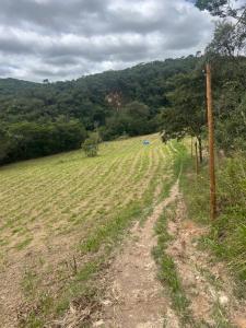 a field with a dirt road in a field at Camping Cachoeira Bem Vinda in Itabirito