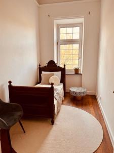 a bedroom with a bed and a window and a rug at Ambiente Deluxe Schloss Falkenhorst in Kleinblittersdorf