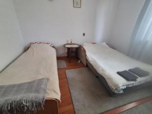 two beds in a small room with a table at ,,Arts Home,, ,ZAPRASZAM ,blisko las,dużo przyrody, blisko centrum kardiologii,centrum szkoleniowe,trasa na Lublin,Ukrainę,mieszkanie przestronne,czyste,spokojna okolica,blisko Aldi,Lidl,Żabka,Rossmann,pkp, ztm in Warsaw