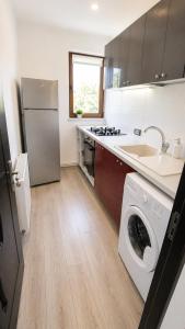 a kitchen with a washer and a sink and a refrigerator at Apartament Vila Draghici Eforie Sud in Eforie Sud