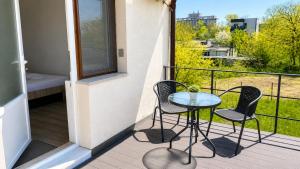 a balcony with a table and two chairs and a bed at Apartament Vila Draghici Eforie Sud in Eforie Sud