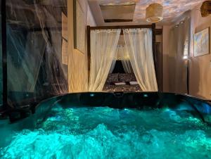 a jacuzzi tub in the middle of a room at Loveroom Romantique avec Spa et Secret Room - A proximité des Lacs - La Mure in La Mure