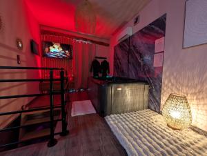 a red room with a bunk bed and a lamp at Loveroom Romantique avec Spa et Secret Room - A proximité des Lacs - La Mure in La Mure