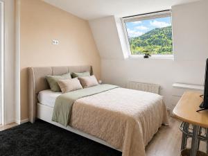 a small bedroom with a bed and a window at Residence L'Horizon in Murat-le-Quaire