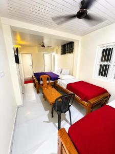 a room with two beds and a table and chairs at Classic Comfort in Chikmagalūr