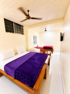 a bedroom with a bed and a ceiling fan at Classic Comfort in Chikmagalūr
