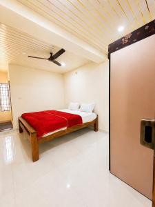 a bedroom with a bed with a red blanket at Classic Comfort in Chikmagalūr +2 photos