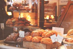 a bakery with a bunch of croissants and other pastries at Royal Awadh Inn in Ayodhya