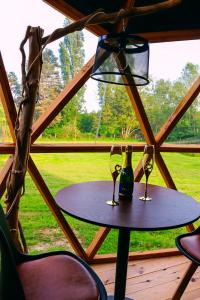 a table with two wine glasses and a lamp at Le Havre de Chaux in La Bretenière