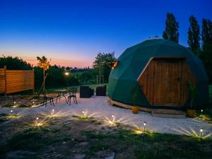 a yurt with a table and chairs at night at Le Havre de Chaux in La Bretenière