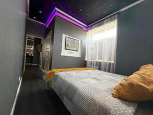 a bedroom with a bed with a purple ceiling at MaxiMar Apartment With Sauna in Valga +18 photos