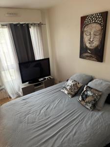 a bedroom with a bed with a picture of a head at Charmant studio à Paris La Défense in Courbevoie