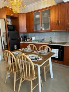 a kitchen with a wooden table with chairs and a counter at King George in Korinos