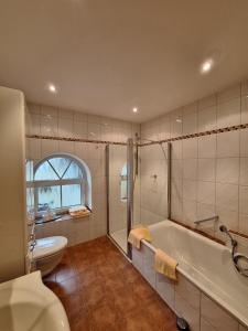 a bathroom with a tub and a toilet and a sink at Bleckmanns Hof in Werne an der Lippe +58 photos
