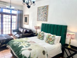 a bedroom with a bed with a green headboard at Franschhoek Mountain Escape in Franschhoek