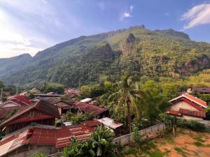 a village with a mountain in the background at Valley Villa Hotel in Nongkhiaw