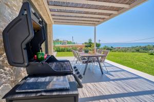 a bbq on a deck with a table and a grill at Arillas Villas in Arillas
