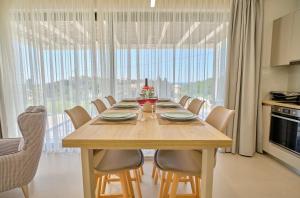 a dining room table with chairs and a large window at Arillas Villas in Arillas