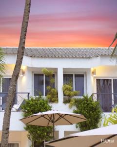 a umbrella sitting in front of a building with a sunset at H2Otel By LD Hotel Boutique in La Mira
