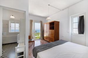 a white bedroom with a bed and a bathroom at vv Rincón Solaris in Tijarafe