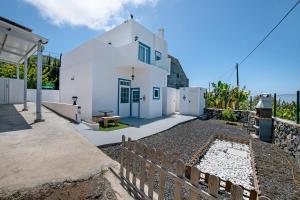 a white house with a fence in front of it at vv Rincón Solaris in Tijarafe
