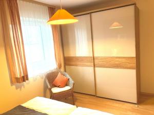 a bedroom with a door with a chair and a window at Ferienwohnung Bartels in Petersdorf mit Terrasse in Fehmarn