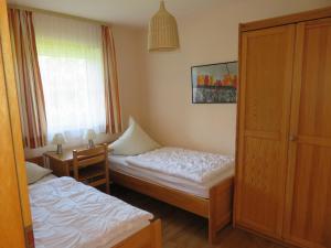 a small room with two beds and a window at Ferienwohnung Bartels in Petersdorf mit Terrasse in Fehmarn