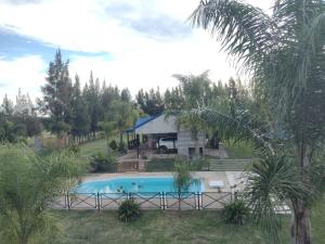 a house with a swimming pool in the yard at Cabañas y Bungalow " La Comarca" in Concepción del Uruguay