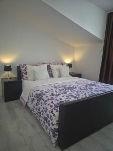 a bedroom with a large bed with a purple comforter at APARTMENT D&D in Split