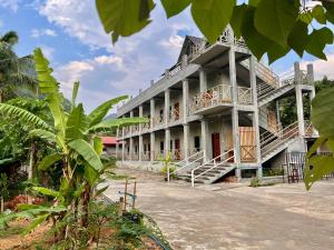 a building with a balcony and stairs on it at Valley Villa Hotel in Nongkhiaw