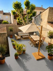 a patio with an umbrella and chairs and plants at Another World Village house in Buis-les-Baronnies