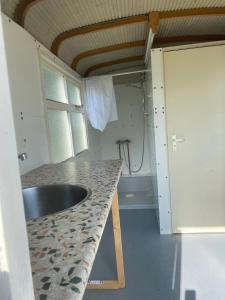 a kitchen with a sink and a counter top at Pipowagen Utewyn in Reitsum