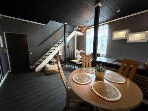 a dining room with a table and chairs and a staircase at MaxiMar Apartment With Sauna in Valga