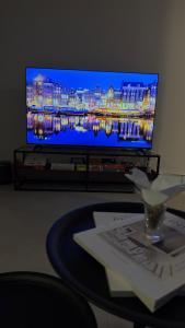 a living room with a tv and a table with a table sidx sidx at AURA Stay in Dammam
