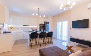 a kitchen and living room with a table and chairs at La Marine Apartments in Kalandra