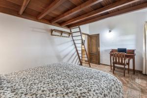 a bedroom with a bed and a desk and a ladder at vv Casa Rural El Pajar in El Pinar del Hierro