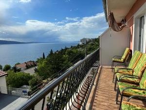 a balcony with chairs and a view of the water at Apartments & Room MaDi in Senj