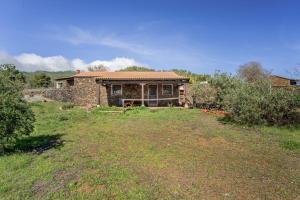 a stone house with a yard in front of it at vv Casa Rural El Pajar in El Pinar del Hierro