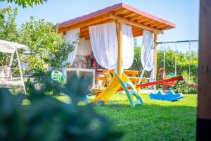 a childrens playground with a play structure in the grass at La Marine Apartments in Kalandra